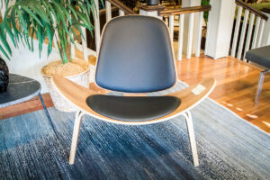 Wooden chair with an extended curved seat and black padding