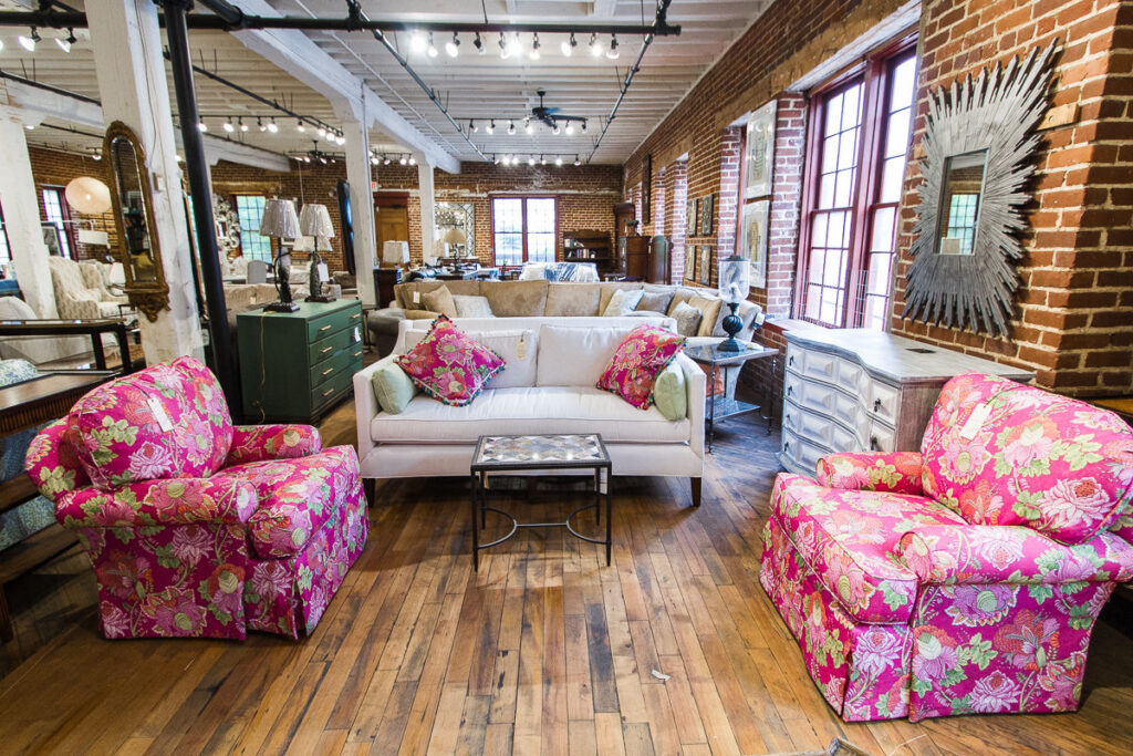 Two plush chairs with pink floral upholstery in the Green Front Furniture warehouse