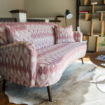 patterned pink couch on an animal skin rug