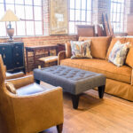 tan couch with a gray quilted bench and light brown armchair in front
