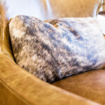 animal print patterned pillow on a light brown leather couch