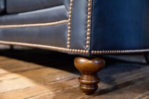 wooden leg on Leather Couch in Green Front Furniture showroom