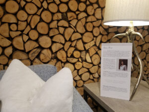 Stanford couch in front of a wall of cut wood logs