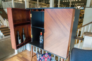 medium brown bar cabinet with alcohol bottles inside