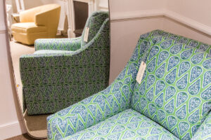 Light green armchair with triangular patterns in front of a rectangular mirror