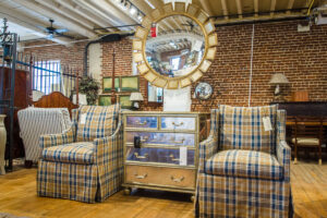 two plaid armchairs separated by a small cabinet with metallic drawers