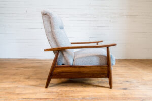 side view of an armchair with gray cushions and medium brown arms and legs