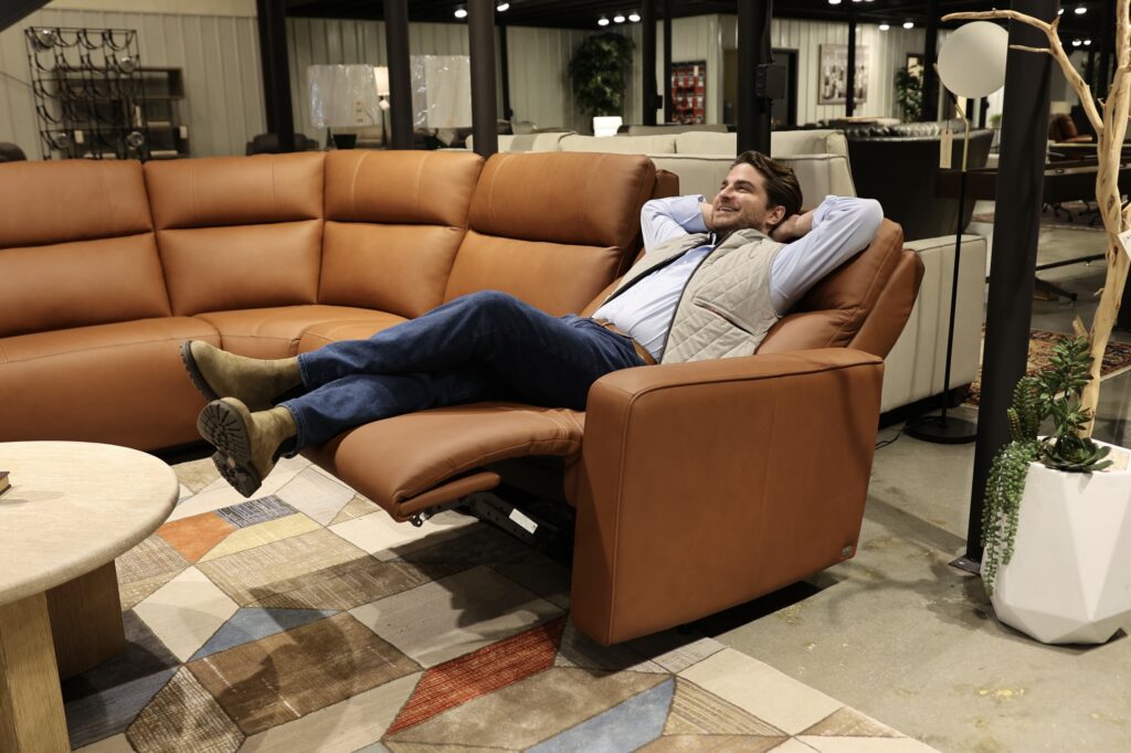 Green front design in motion, brown leather reclining sectional